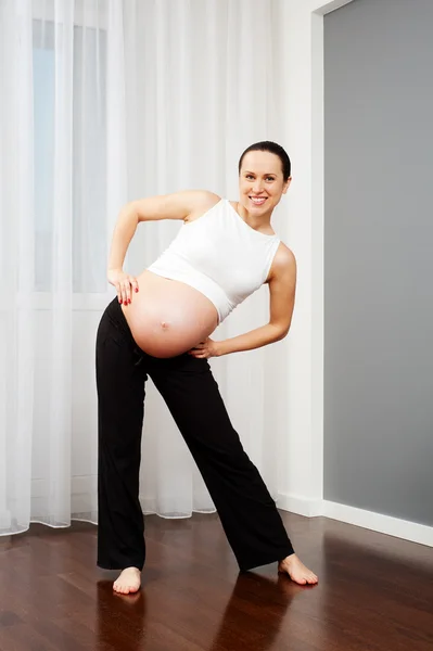 Kobieta w ciąży robi gimnastyczne — Zdjęcie stockowe