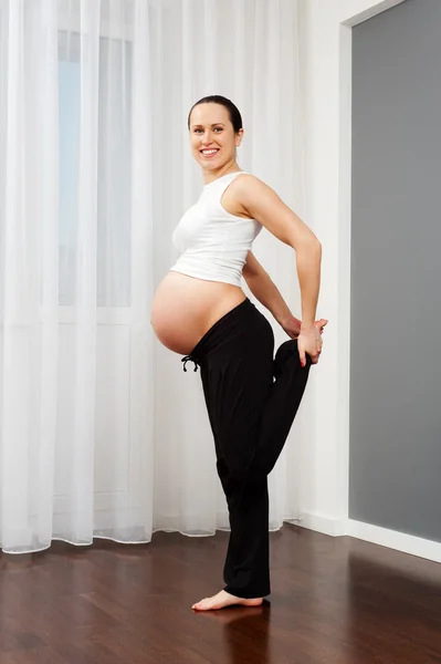Mujer embarazada haciendo ejercicio de estiramiento — Foto de Stock
