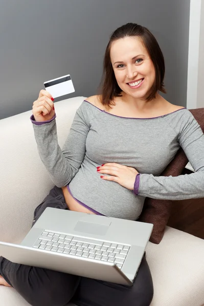 Беременная женщина с ноутбуком и кредитной картой — стоковое фото