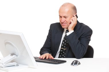 Businessman sitting at desk in office clipart