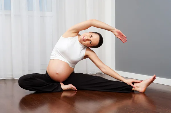 Těhotná žena, která dělá gymnastika — Stock fotografie