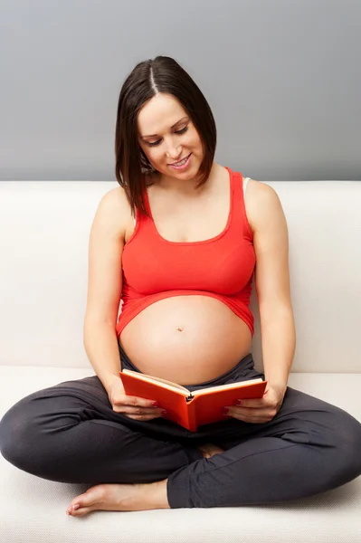 Gravid kvinna läsa bok — Stockfoto