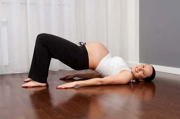 Evde egzersiz yaparak gülen hamile kadın — Stok fotoğraf