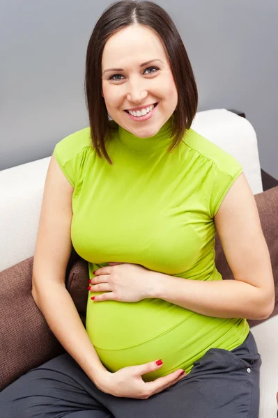 笑脸孕妇在绿色 t 恤 免版税图库照片