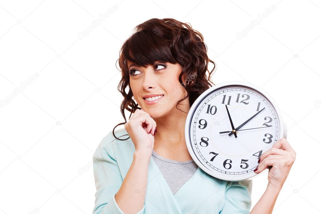 Thoughtful young woman holding clock