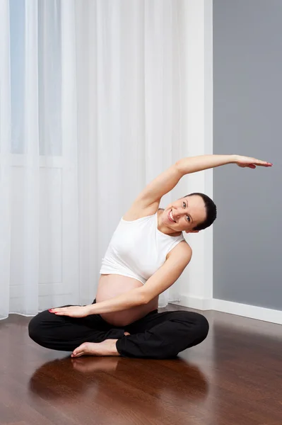怀孕妇女在家练习瑜伽 — 图库照片