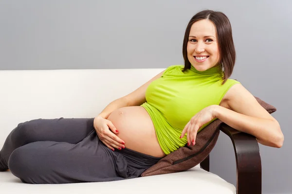 Mujer embarazada acostada en el sofá — Foto de Stock
