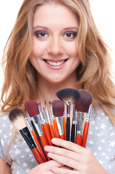 Mulher sorridente com ferramentas de maquiagem — Fotografia de Stock