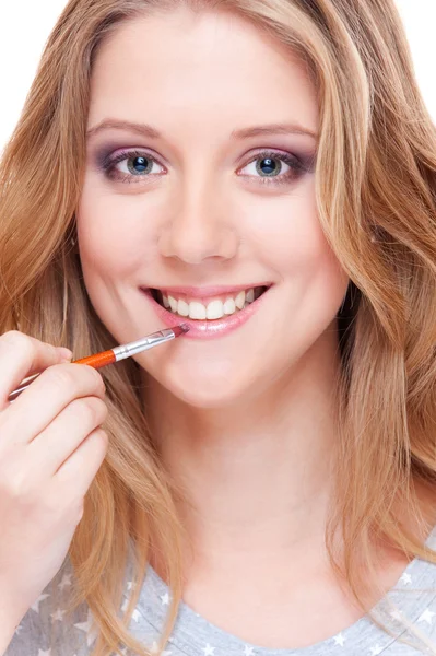 Mujer joven aplicando lápiz labial —  Fotos de Stock