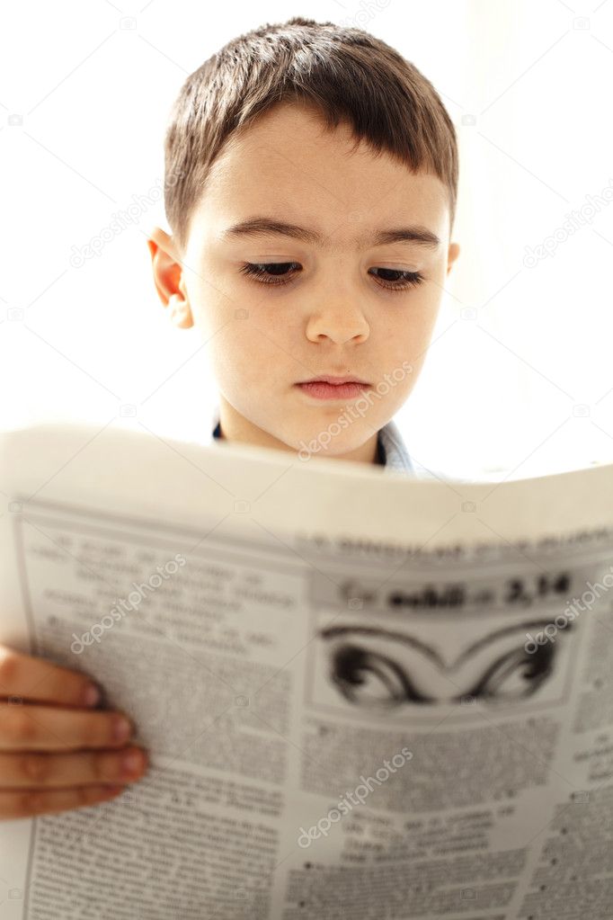 Little boy reading newspaper