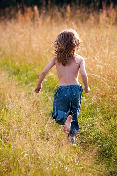 Дитина біжить по шляху в полі — стокове фото
