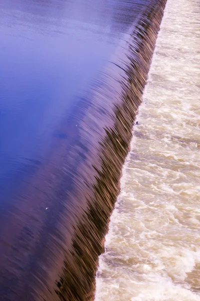 Water stroomt over weir — Stockfoto