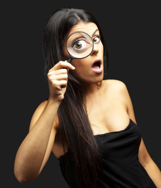 Portrait of young woman surprised looking through a magnifying g clipart