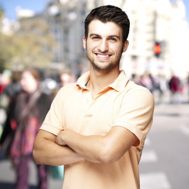 Portrait of a comely young man smiling at a crowded street clipart