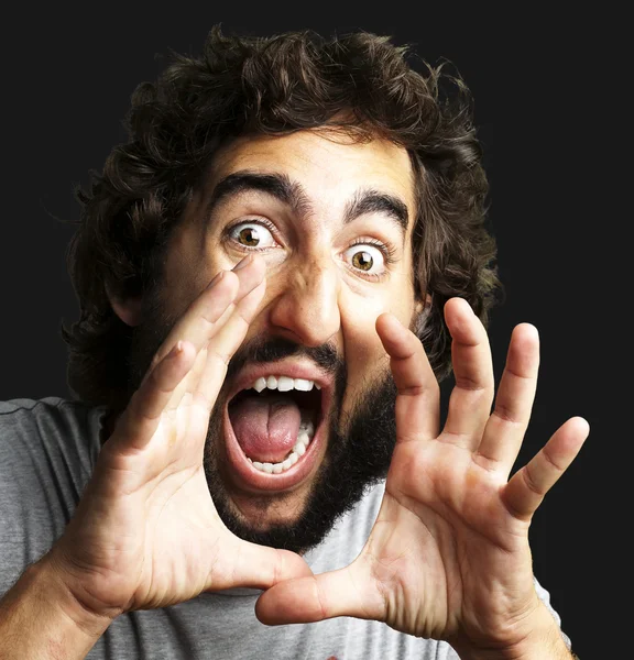 Portrait of young man screaming against a black background — Stock Photo, Image