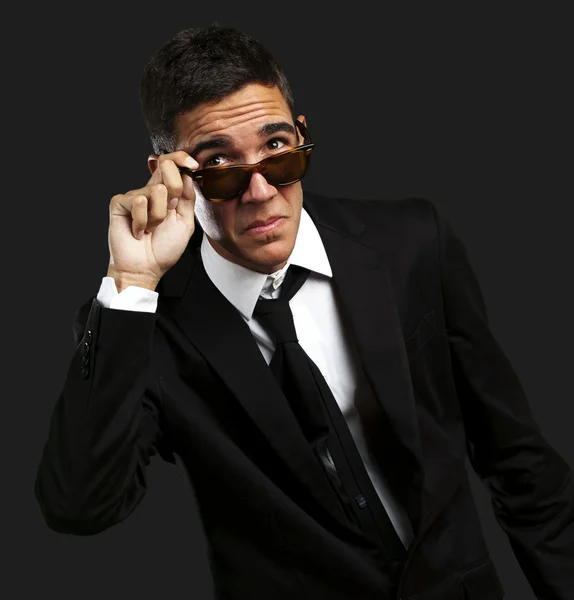 Porträt eines Geschäftsmannes, der die Sonnenbrille gegen einen bla abnimmt — Stockfoto