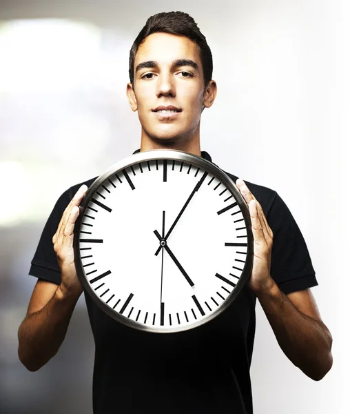 Молодий чоловік тримає годинник — стокове фото