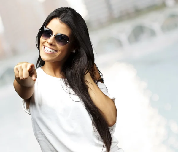 Portrait of pretty young woman pointing with finger and smiling — Stock Photo, Image