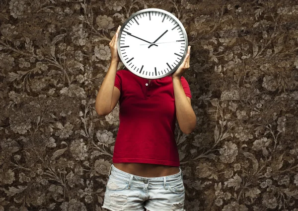 Женщина держит часы — стоковое фото