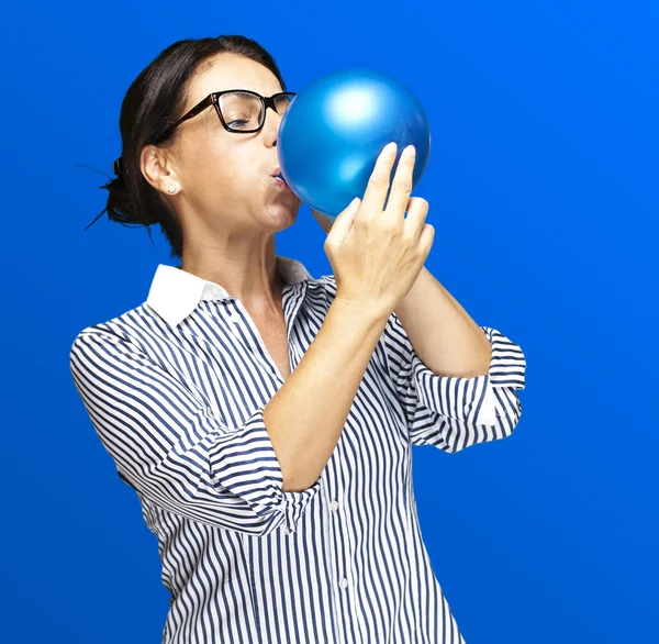 Kobieta dmuchanie balon — Zdjęcie stockowe