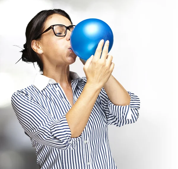 Kvinna blåser ballong — Stockfoto