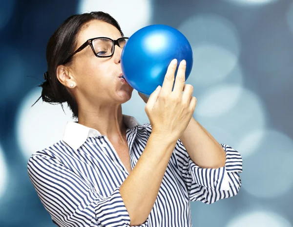 Woman blowing balloon