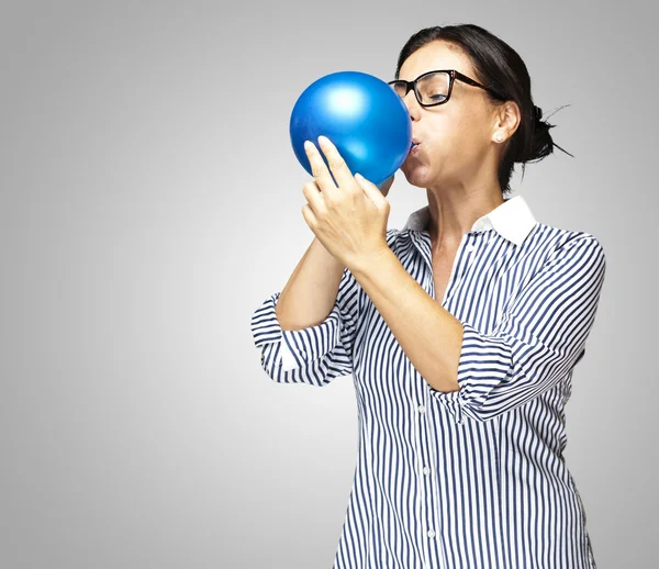 Woman blowing balloon — Stock Photo, Image