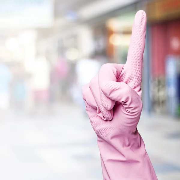 Kobieta z różowe rękawiczki gestykulacji przeciwko zatłoczonym miejscu — Zdjęcie stockowe