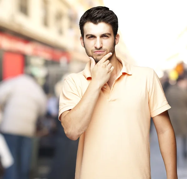 Портрет милого молодого человека, думающего на переполненной улице — стоковое фото