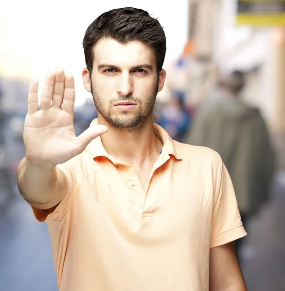 Ortrait güzel, genç bir adamın stop sembolü, kalabalık bir cadde yapıyor — Stok fotoğraf