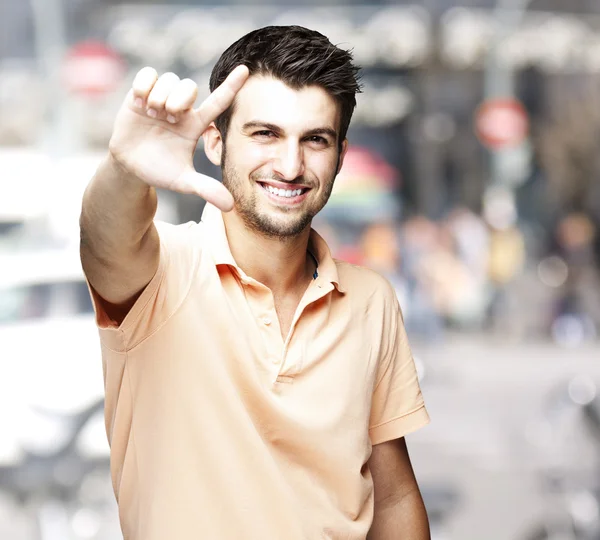 Portrait of a handsome man doing good symbol at a crowded city — Stock Photo, Image