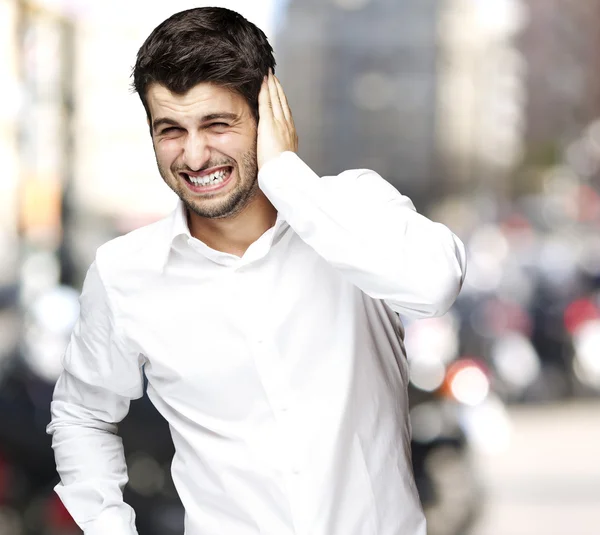 Porträt eines jungen Mannes irritiert Hören eines lauten in der Stadt — Stockfoto