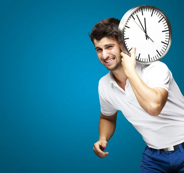 Portret przystojny młody mężczyzna prowadzenia zegar z niebieskim — Zdjęcie stockowe