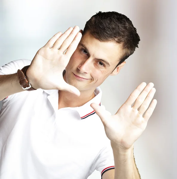 Portrét mladého muže, dělá fotografie gesto proti abstraktní bac — Stock fotografie