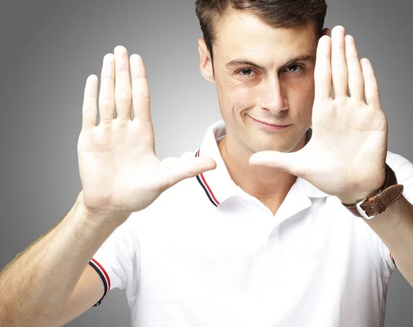 Portrait of young man doing photo gesture over grey background — Stock Photo, Image