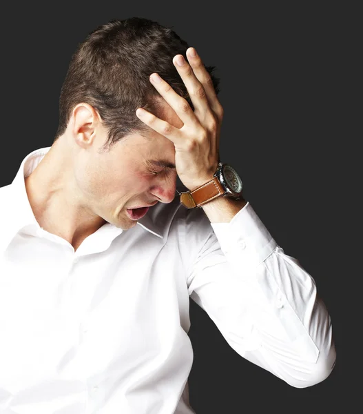 Angry young man doen frustratie gebaar op zwarte achtergrond — Stockfoto
