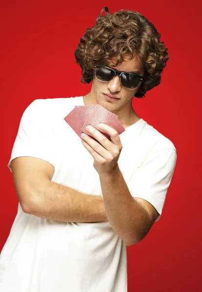 Портрет молодого чоловіка в сонцезахисних окулярах і гра в покер над — стокове фото