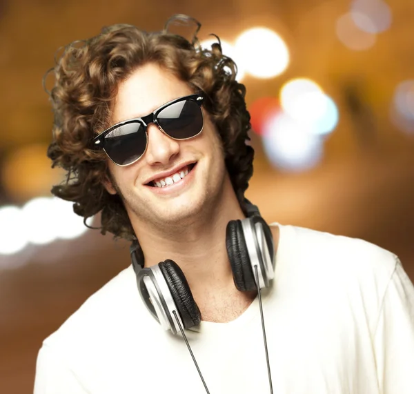 Porträt eines jungen Mannes mit Kopfhörern bei Nacht in der Stadt — Stockfoto