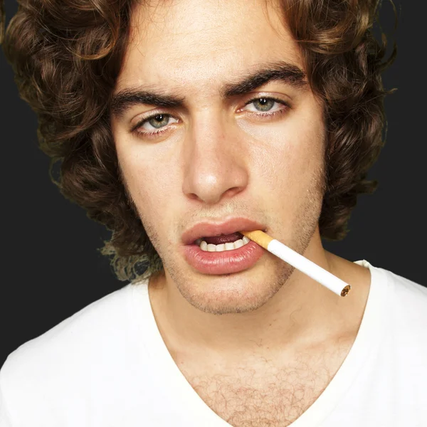 Porträt eines traurigen Rauchers vor schwarzem Hintergrund — Stockfoto