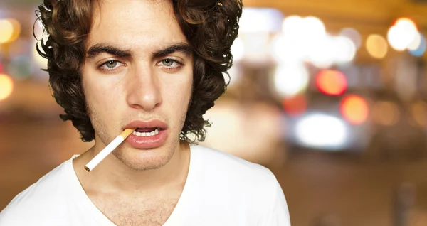 Portrait of a sad smoker at crowded city — Stock Photo, Image