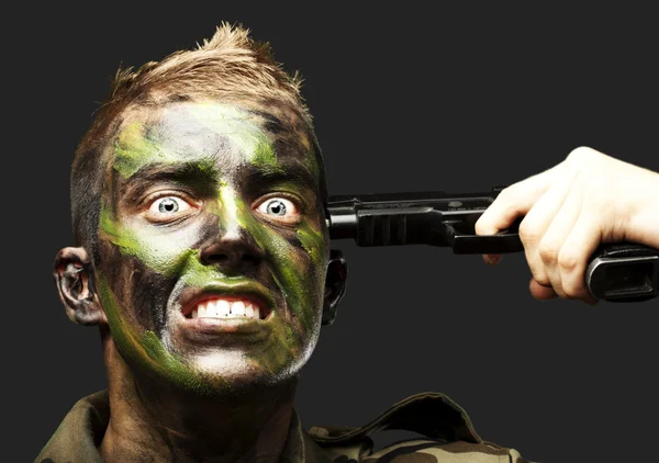 Portrait of young soldier comiting suicide over black background — Stock Photo, Image