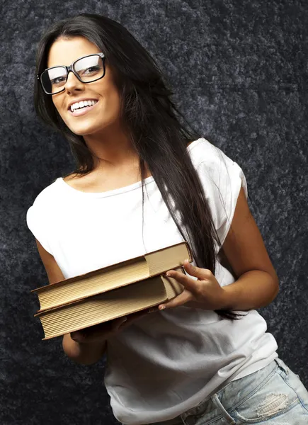 Portrait of young girl holding books against a grunge wall Stock Image