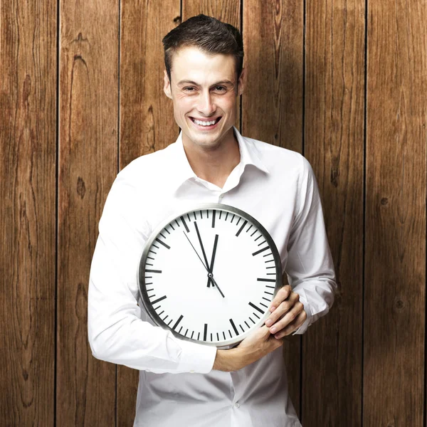 Young man holding clock Royalty Free Stock Images