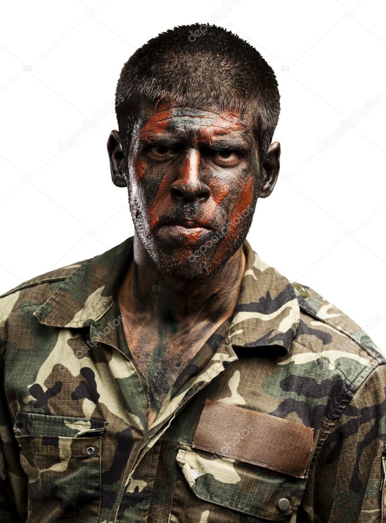 Young soldier with camouflage paint looking very serious over wh