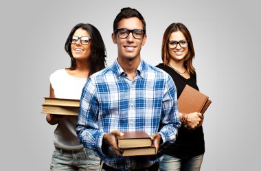 Young students holding books over grey background clipart