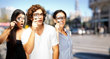 Young scientifics looking through a magnifying glass at city clipart