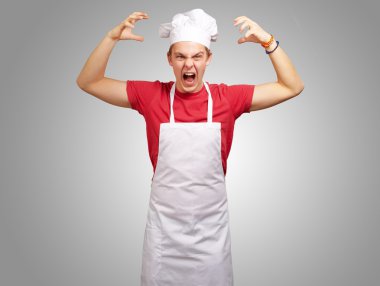 agresif gestur yapıyor önlük giyen genç aşçı adam portresi