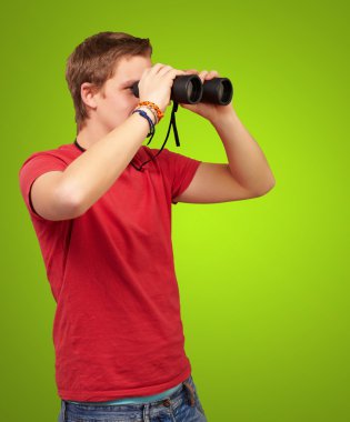 Yeşil ba bir dürbün ile bakan genç adam portresi
