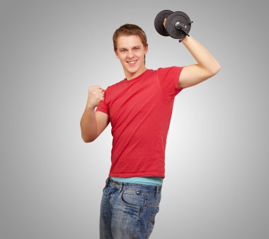 genç adam gri arka plan üzerinde Fitness ağırlık yapıyor