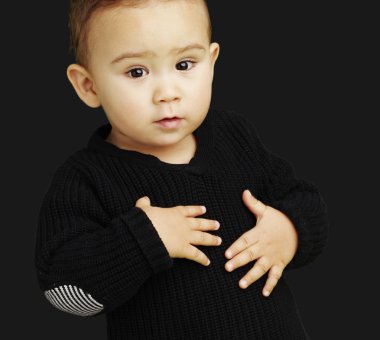 Portrait of adorable kid touching his stomach against a black ba clipart